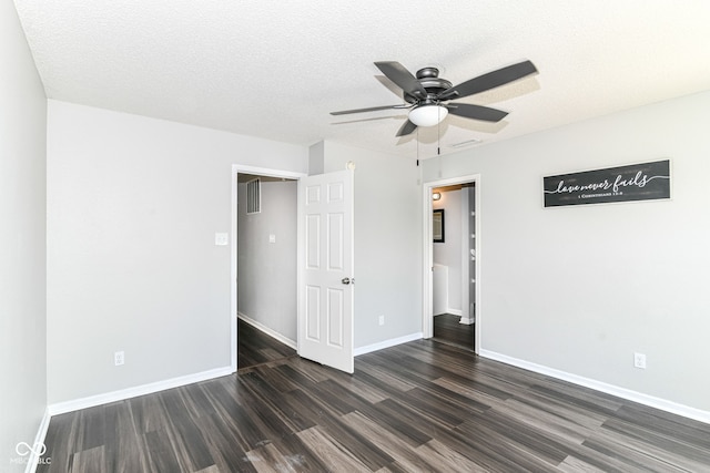 9676 W Constellation Dr, Pendleton, IN 46064 - unfurnished bedroom with dark wood finished floors, baseboards, ceiling fan, and a textured ceiling