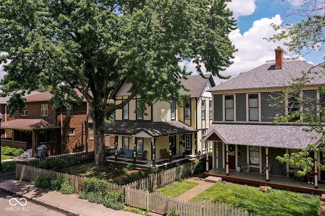 847 N Park Ave, Indianapolis, IN 46202 - view of front of property with covered porch, a chimney, a fenced front yard, and a shingled roof