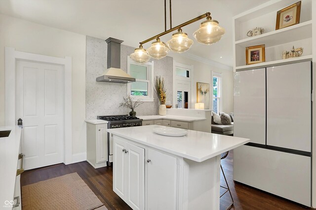 847 N Park Ave, Indianapolis, IN 46202 - kitchen with freestanding refrigerator, high end stove, wall chimney exhaust hood, dark wood finished floors, and light countertops