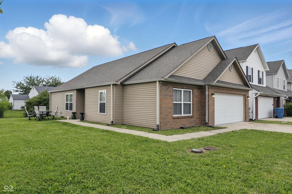 608 Fisher Creek Dr, Indianapolis, IN 46239 - view of property exterior featuring an attached garage, a lawn, brick siding, driveway, and a shingled roof