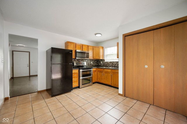 6715 Wandering Way, Indianapolis, IN 46241 - kitchen featuring stainless steel appliances, dark countertops, backsplash, light tile patterned floors, and baseboards