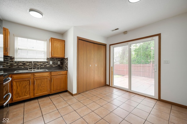 6715 Wandering Way, Indianapolis, IN 46241 - kitchen with a sink, dark countertops, healthy amount of natural light, backsplash, and a textured ceiling