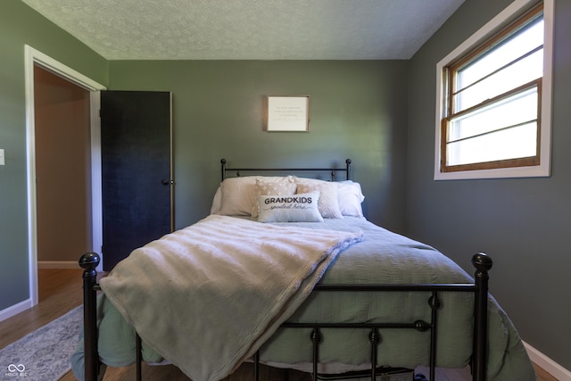 6310 E County Road 200 S, Butlerville, IN 47223 - bedroom with wood finished floors and a textured ceiling
