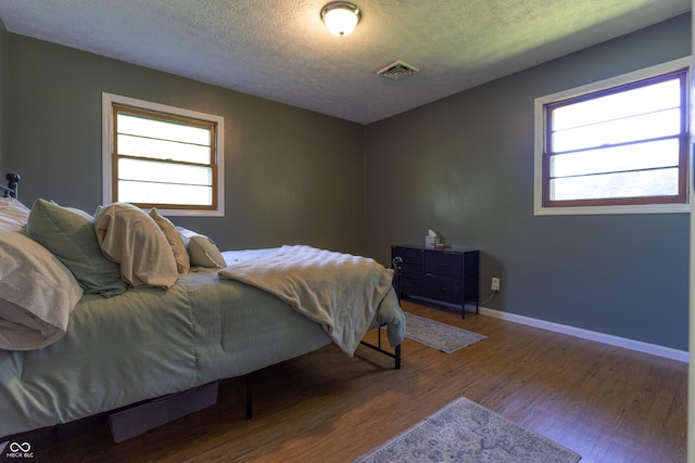 6310 E County Road 200 S, Butlerville, IN 47223 - bedroom featuring wood finished floors, multiple windows, and a textured ceiling