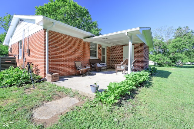 6310 E County Road 200 S, Butlerville, IN 47223 - back of property featuring brick siding, a lawn, and a patio
