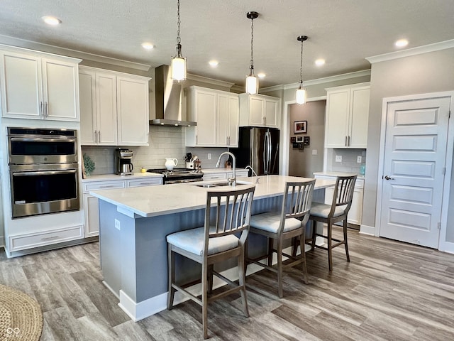 3691 Talmine Ln, Bargersville, IN 46106 - kitchen featuring wall chimney exhaust hood, stainless steel appliances, a sink, ornamental molding, and a center island with sink