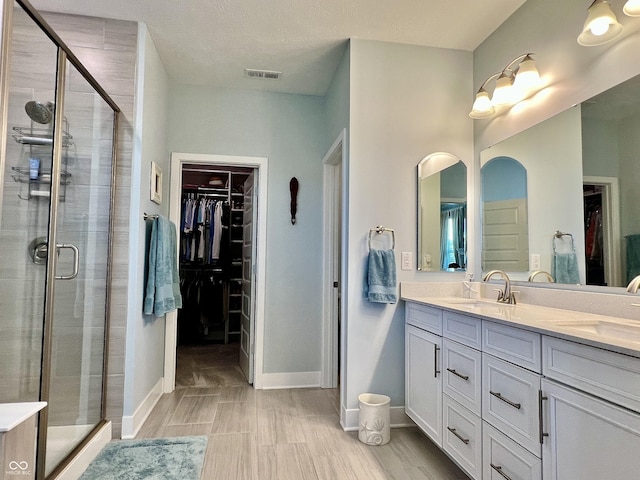 3691 Talmine Ln, Bargersville, IN 46106 - bathroom with a walk in closet, double vanity, a shower stall, and baseboards