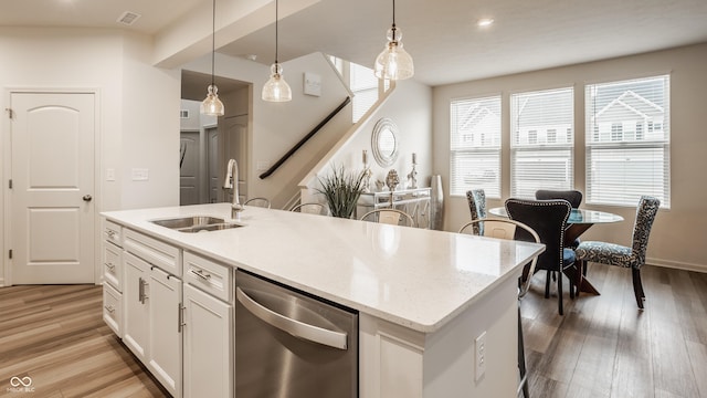 747 Tuxedo Dr, Westfield, IN 46074 - kitchen featuring stainless steel dishwasher, a sink, light wood-type flooring, hanging light fixtures, and white cabinets