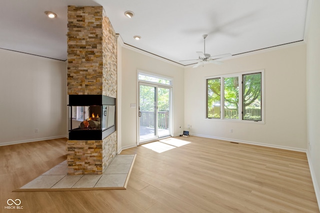 1941 Orchard Ct, Carmel, IN 46280 - unfurnished living room with a stone fireplace, crown molding, light wood finished floors, ceiling fan, and baseboards