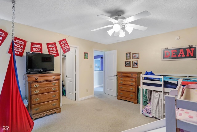 carpeted bedroom with a textured ceiling and a ceiling fan