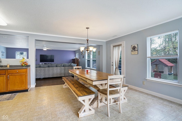 dining area with light flooring, a chandelier, baseboards, ornamental molding, and a ceiling fan