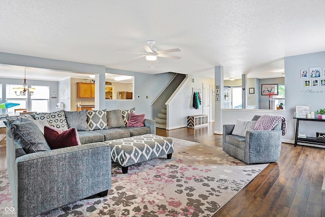 living room with hardwood / wood-style flooring, a chandelier, stairway, ceiling fan, and a textured ceiling
