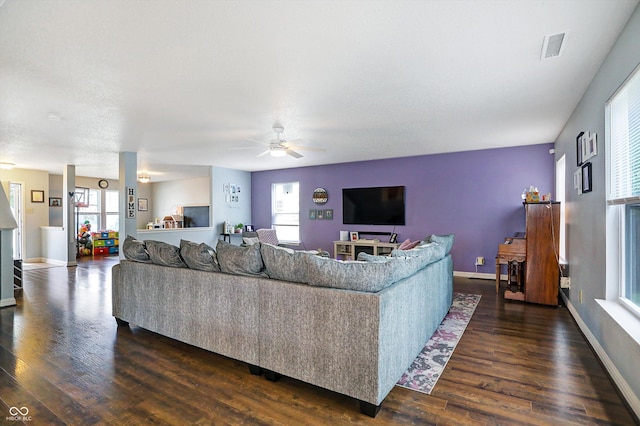 living area with dark wood-style floors, a ceiling fan, and baseboards