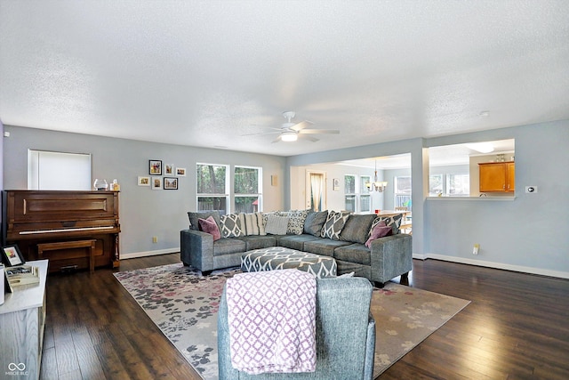 living room with a chandelier, ceiling fan, baseboards, a textured ceiling, and dark wood finished floors