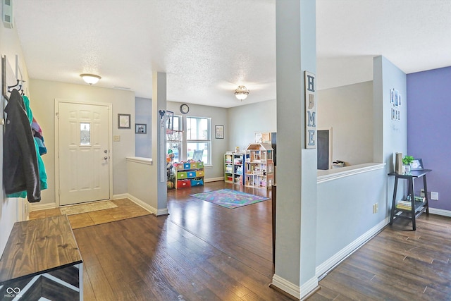 foyer featuring wood finished floors, baseboards, and a textured ceiling