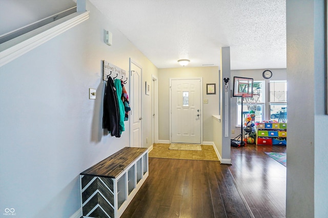 foyer featuring dark wood-type flooring, baseboards, and a textured ceiling