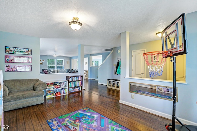 game room featuring wood-type flooring, baseboards, a textured ceiling, and ceiling fan