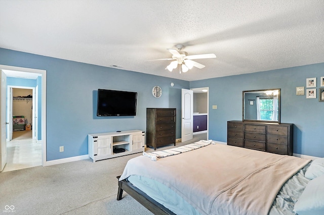 carpeted bedroom with a textured ceiling, baseboards, and a ceiling fan