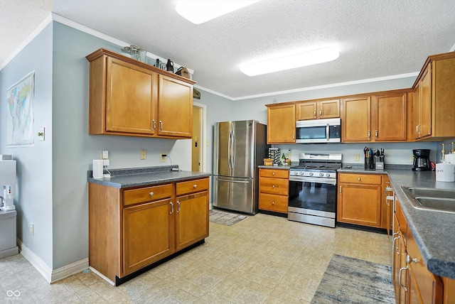 kitchen featuring appliances with stainless steel finishes, brown cabinets, dark countertops, a textured ceiling, and ornamental molding
