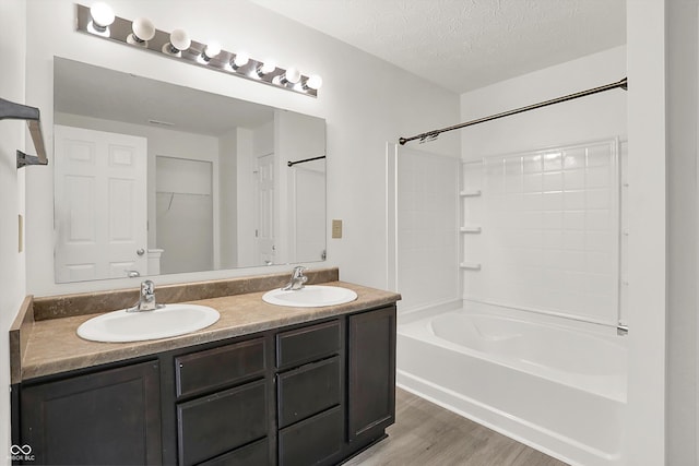 3222 Enclave Ln, Greenwood, IN 46143 - bathroom with wood finished floors, double vanity, tub / shower combination, and a textured ceiling