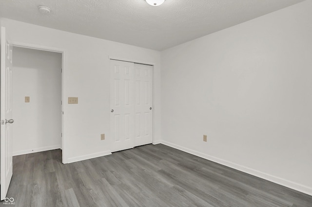 3222 Enclave Ln, Greenwood, IN 46143 - unfurnished bedroom featuring wood finished floors, baseboards, a closet, and a textured ceiling