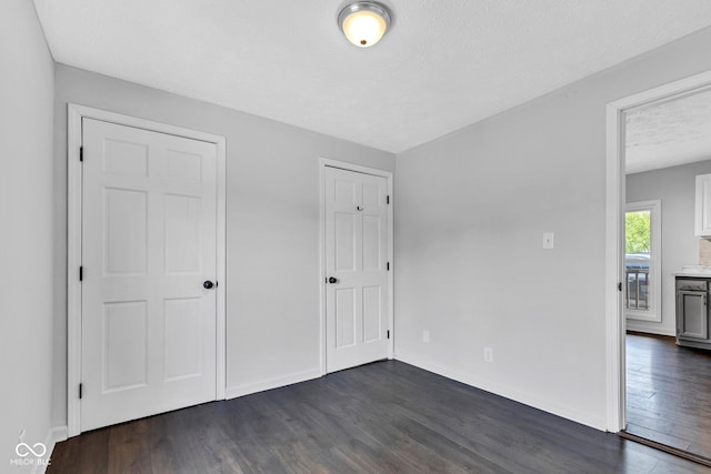 1237 W State Rd 38, Pendleton, IN 46064 - unfurnished bedroom with dark wood-style flooring, baseboards, and a textured ceiling