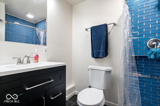 bathroom featuring toilet, vanity, baseboards, a tile shower, and tile patterned flooring