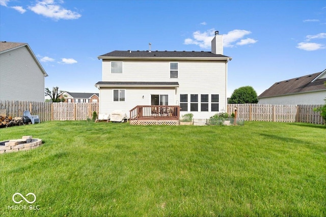 back of house featuring a chimney, a fire pit, and a deck