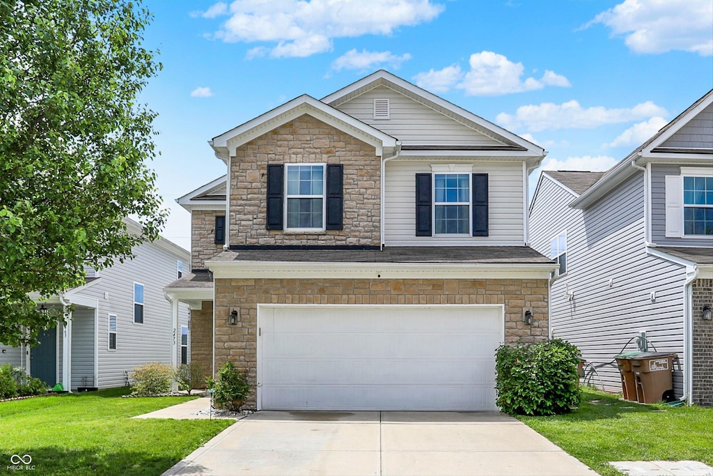 2473 Shadow Bend Dr, Columbus, IN 47201 - view of front of home with stone siding, a garage, concrete driveway, and a front lawn