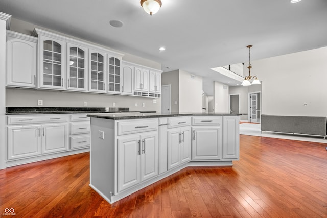 4368 W Eagle Trce, New Palestine, IN 46163 - kitchen with dark countertops, glass insert cabinets, hardwood / wood-style floors, white cabinetry, and recessed lighting