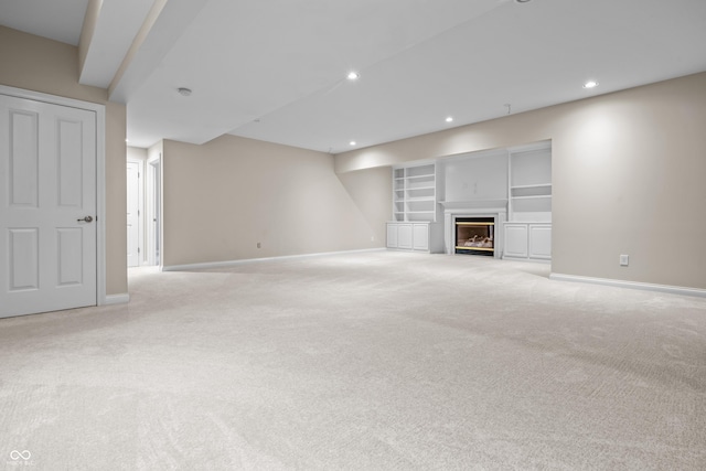 4368 W Eagle Trce, New Palestine, IN 46163 - below grade area with baseboards, light carpet, recessed lighting, built in shelves, and a glass covered fireplace