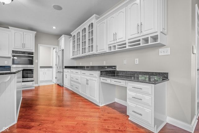 4368 W Eagle Trce, New Palestine, IN 46163 - kitchen featuring stainless steel appliances, white cabinets, glass insert cabinets, light wood-style flooring, and recessed lighting