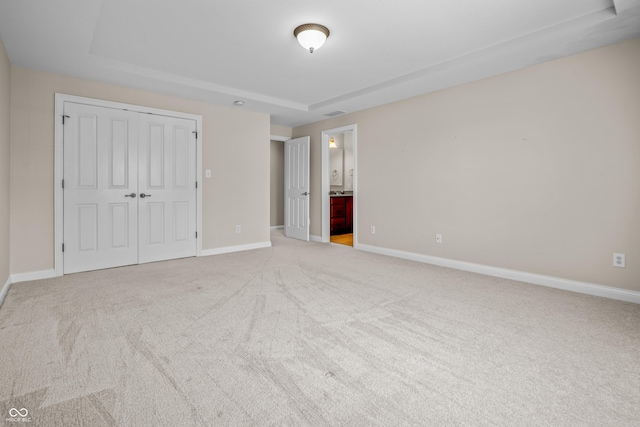 4368 W Eagle Trce, New Palestine, IN 46163 - unfurnished bedroom featuring light colored carpet, a raised ceiling, baseboards, and a closet
