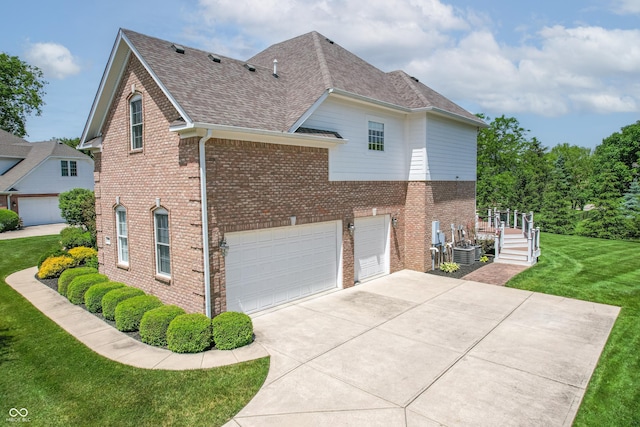 4368 W Eagle Trce, New Palestine, IN 46163 - view of side of property featuring a garage, brick siding, a lawn, and concrete driveway