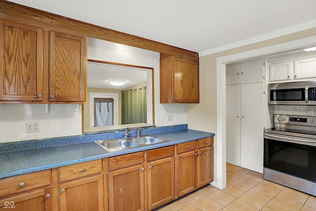 425 Aiken St, Hope, IN 47246 - kitchen with stainless steel appliances, light tile patterned floors, brown cabinetry, tasteful backsplash, and ornamental molding