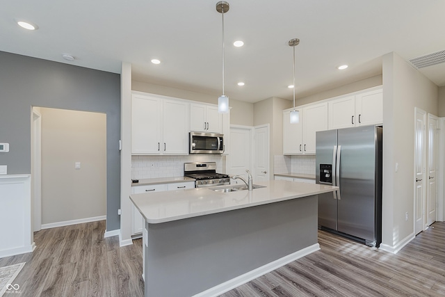 6465 Wasco Dr, Whitestown, IN 46075 - kitchen with appliances with stainless steel finishes, a sink, light wood finished floors, light countertops, and white cabinets