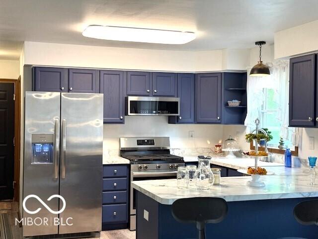 4600 S Tahoe Trl, Crawfordsville, IN 47933 - kitchen with appliances with stainless steel finishes, a peninsula, a kitchen breakfast bar, pendant lighting, and open shelves