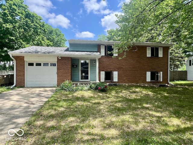 tri-level home featuring a garage, brick siding, and driveway