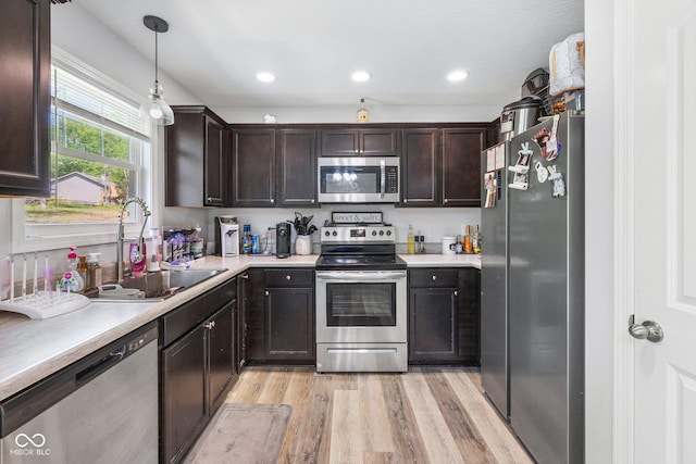 508 Jefferson, Coatesville, IN 46121 - kitchen featuring stainless steel appliances, light wood-style flooring, a sink, dark brown cabinets, and light countertops