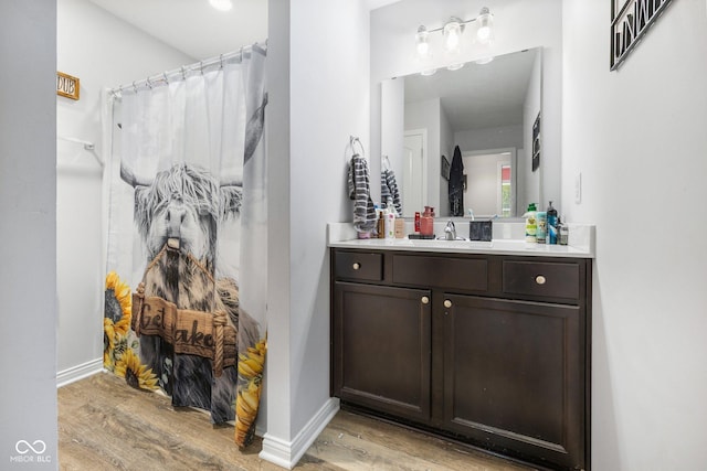 508 Jefferson, Coatesville, IN 46121 - bathroom featuring wood finished floors, a shower with curtain, vanity, and baseboards