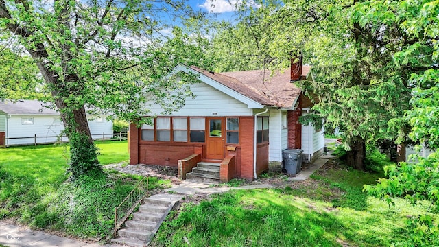 1523 E Mills Ave, Indianapolis, IN 46227 - view of front of home with entry steps, a chimney, brick siding, and roof with shingles