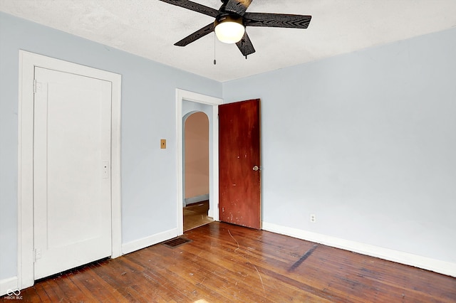1523 E Mills Ave, Indianapolis, IN 46227 - unfurnished bedroom featuring wood-type flooring, baseboards, arched walkways, and ceiling fan