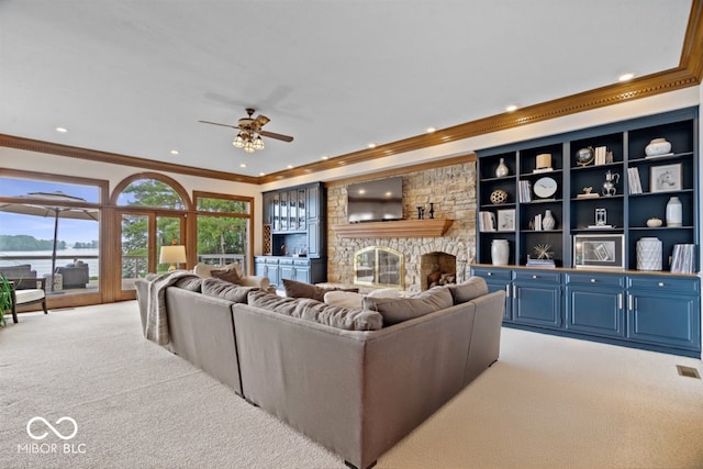 11715 Landings Dr, Indianapolis, IN 46256 - carpeted living area with ornamental molding, a ceiling fan, recessed lighting, a stone fireplace, and a water view