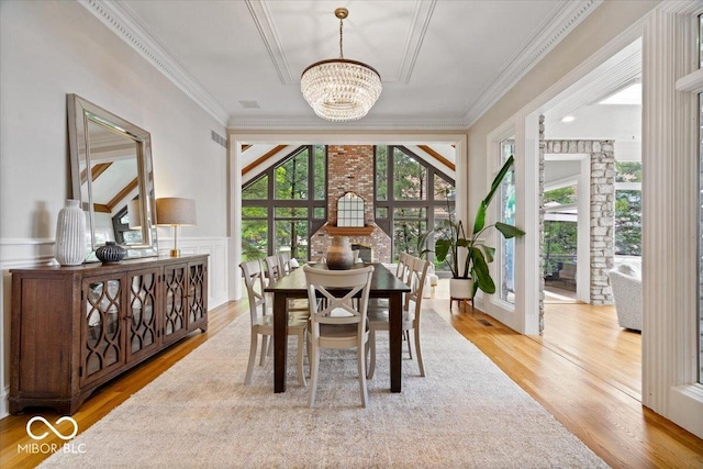 11715 Landings Dr, Indianapolis, IN 46256 - dining room featuring a chandelier, wood finished floors, ornamental molding, and a wainscoted wall
