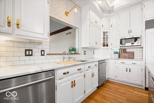 11715 Landings Dr, Indianapolis, IN 46256 - kitchen featuring stainless steel appliances, a sink, white cabinets, tasteful backsplash, and ornamental molding
