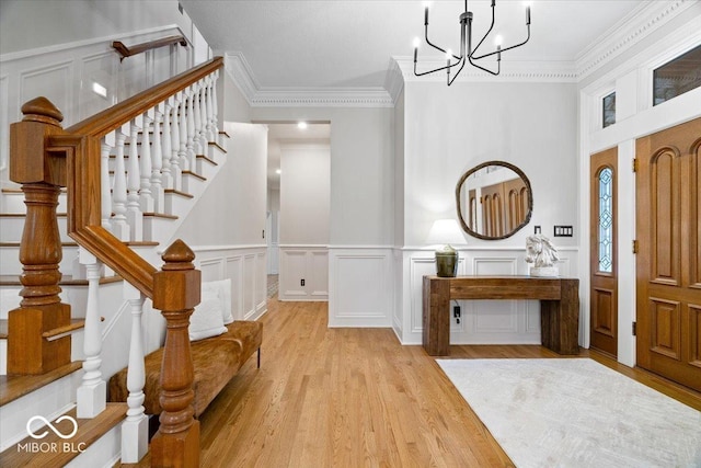 11715 Landings Dr, Indianapolis, IN 46256 - foyer featuring light wood-style flooring, stairway, a chandelier, crown molding, and a decorative wall