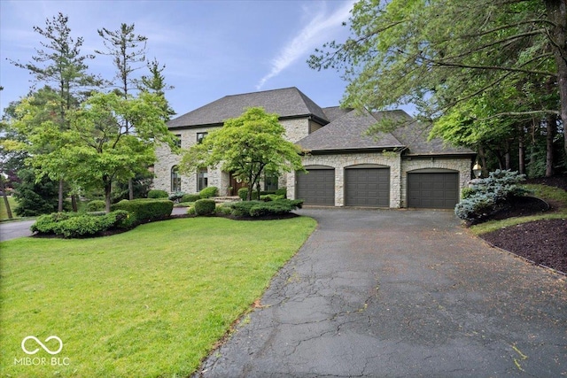 11715 Landings Dr, Indianapolis, IN 46256 - french country home with a garage, a front lawn, driveway, and stone siding