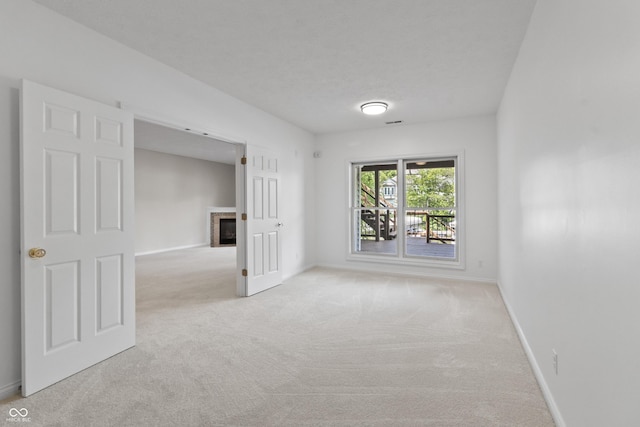 11226 Blackwalnut Pt, Indianapolis, IN 46236 - empty room with carpet flooring, a glass covered fireplace, and baseboards