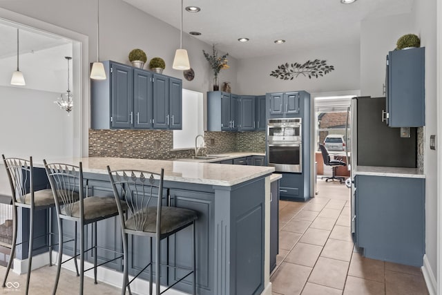 11226 Blackwalnut Pt, Indianapolis, IN 46236 - kitchen featuring a peninsula, a sink, stainless steel double oven, blue cabinets, and decorative backsplash