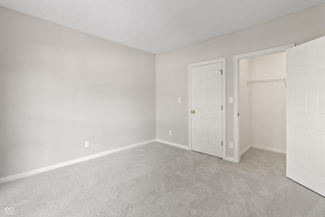 11226 Blackwalnut Pt, Indianapolis, IN 46236 - unfurnished bedroom featuring carpet, baseboards, a walk in closet, and a closet